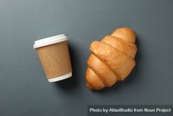 Freshly baked croissant and takeaway coffee on dark grey background, top view bDR9A5