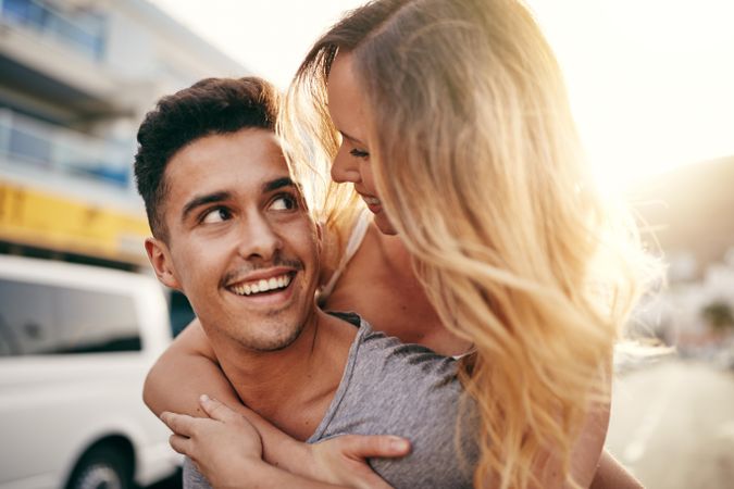 A happy young couple looking lovingly at each other in the sunshine