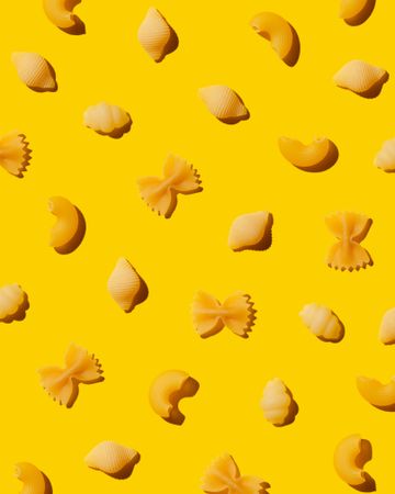 Multiple types of pasta over yellow background