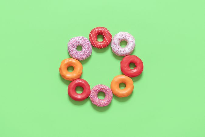 Multicolored doughnuts isolated on green background