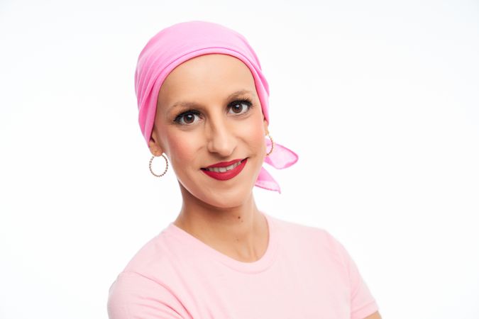 portrait of optimistic woman suffering from cancer with pink head scarf