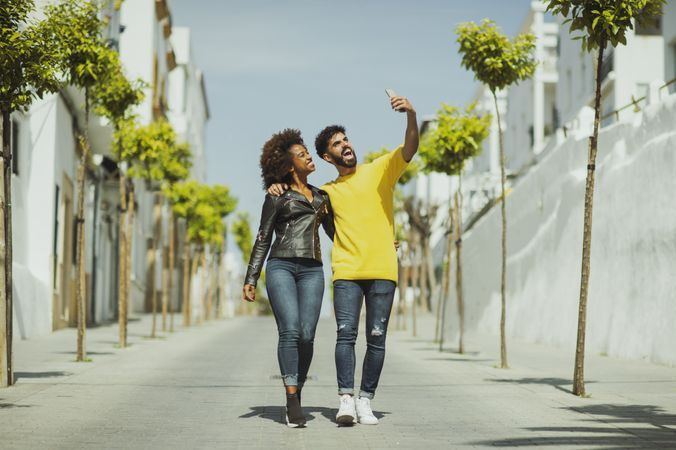 Excited couple walking and taking selfie