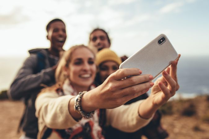 Woman taking selfie with friends on hiking trip
