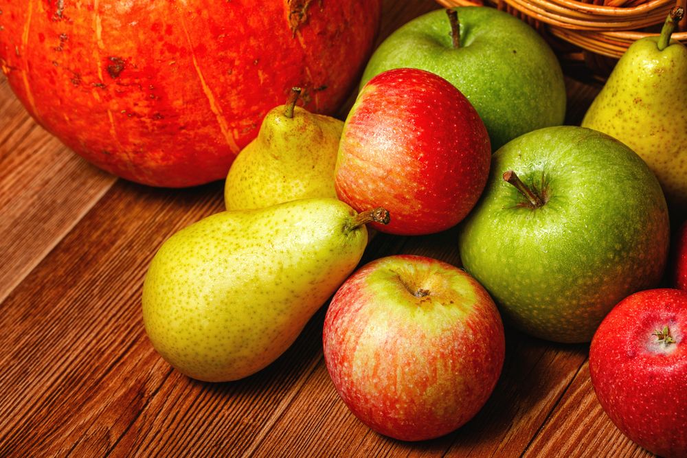 Wooden table with autumnal fruit and squash