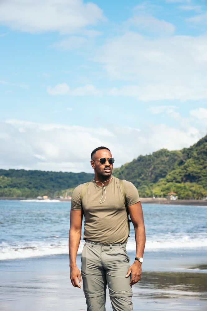 Black man with clothes in the beach