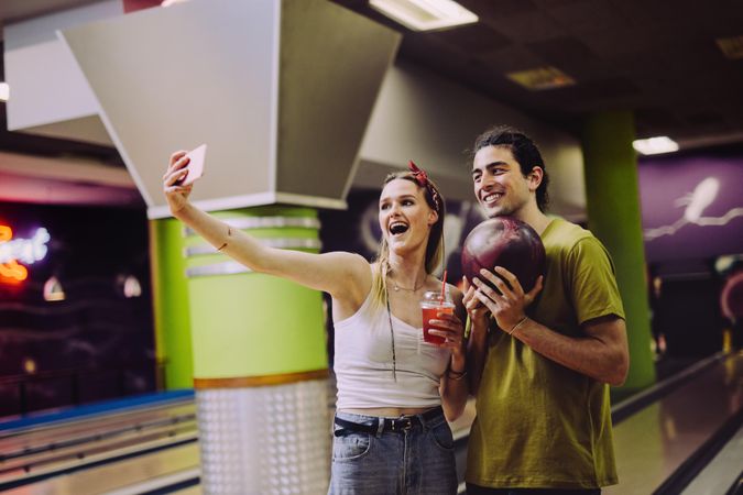 Cute couple taking selfie at bowling alley