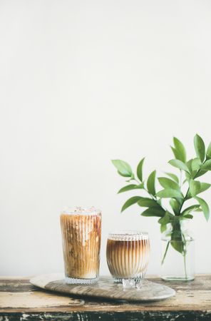 Two glasses of iced coffee with light background with leaves