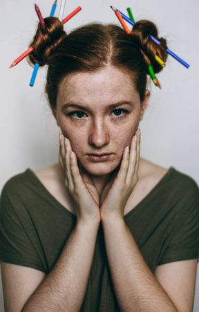 Portrait of young woman in green top with two buns hairstyle