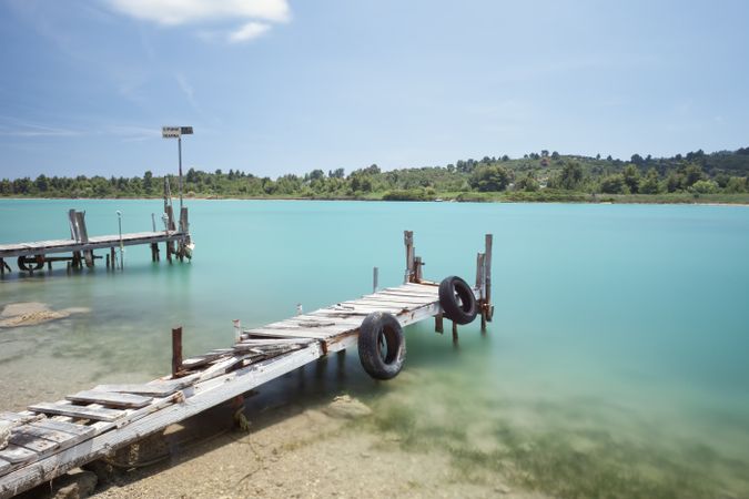 Wooden broken old pier in calm water