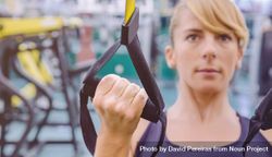 Close up of woman doing upper body exercise with suspension ropes 4A1l64