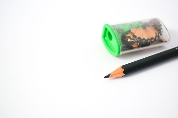 Sharpened pencil next to sharpener on table with space for text