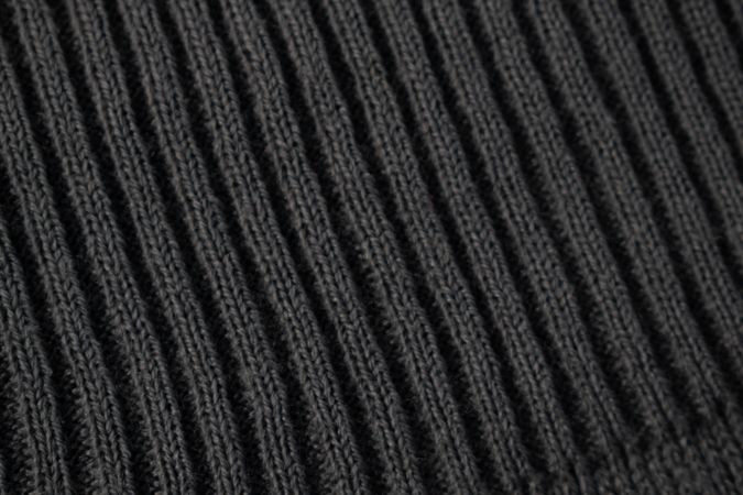 Close up dark grey knitted fabric background texture.