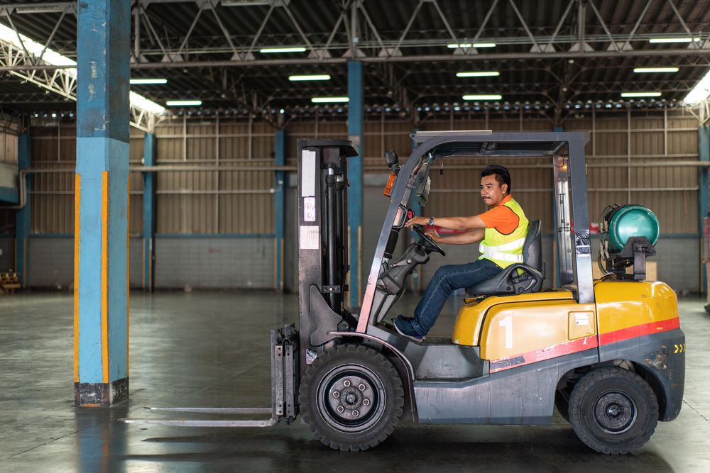 Man driving forklift in distribution center