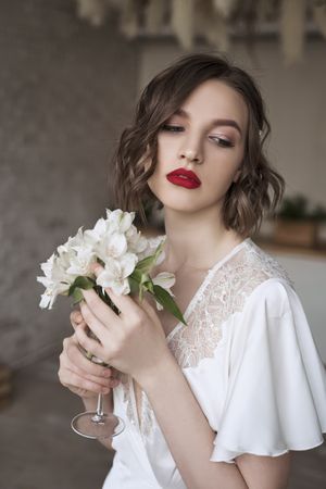 woman with red lips holding white flowers and dreaming