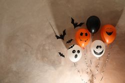 Different balloons on brown background. Halloween concept, space for text