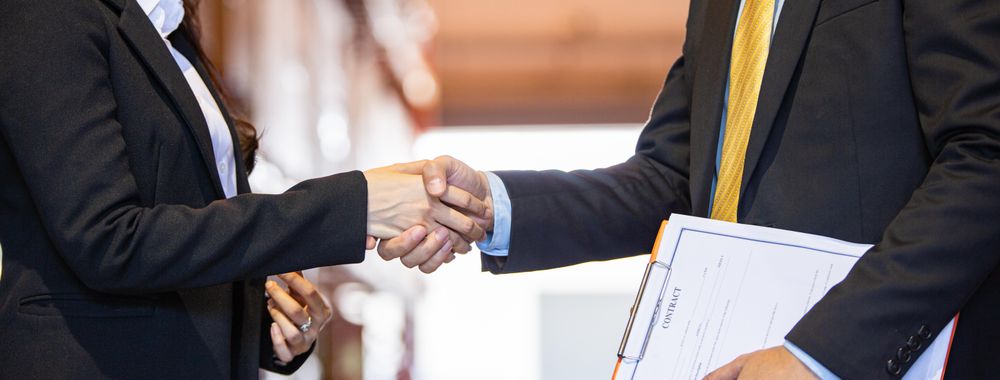 Banner of the hands of two male and female colleagues shaking hands