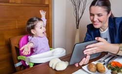 Businesswoman mother and baby girl looking tablet