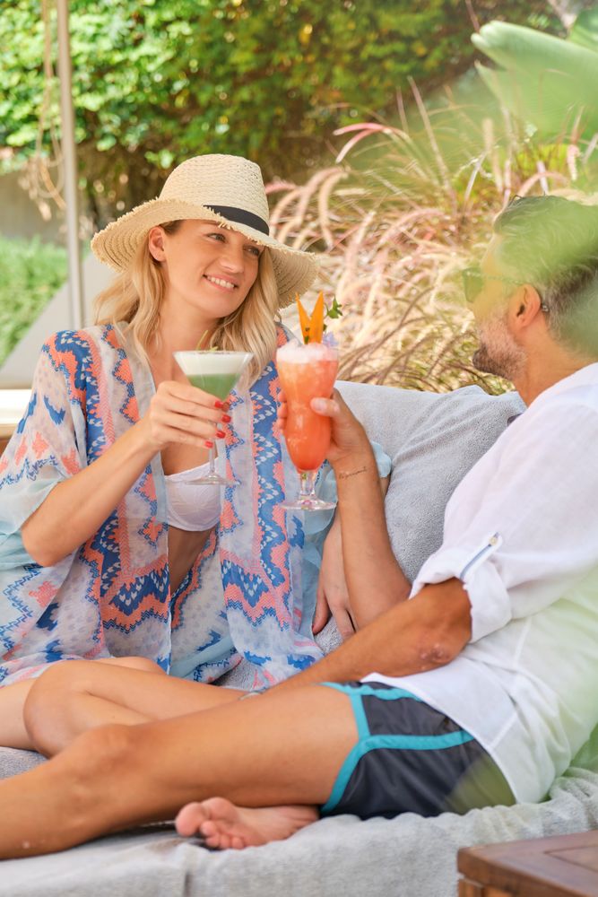 Happy couple enjoying cold drinks in park