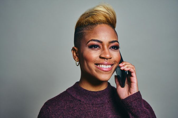 Smiling Black woman speaking on a cell phone