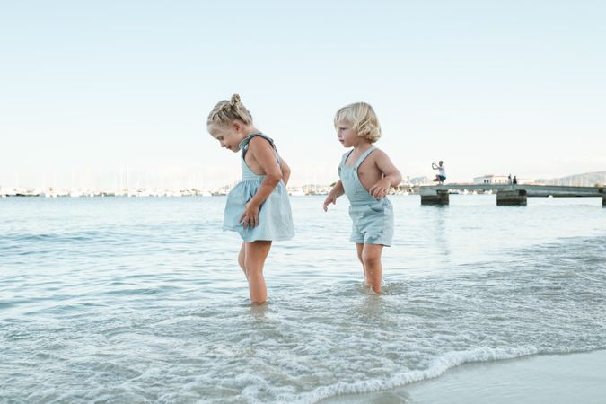 Happy kids walking in sea on beach