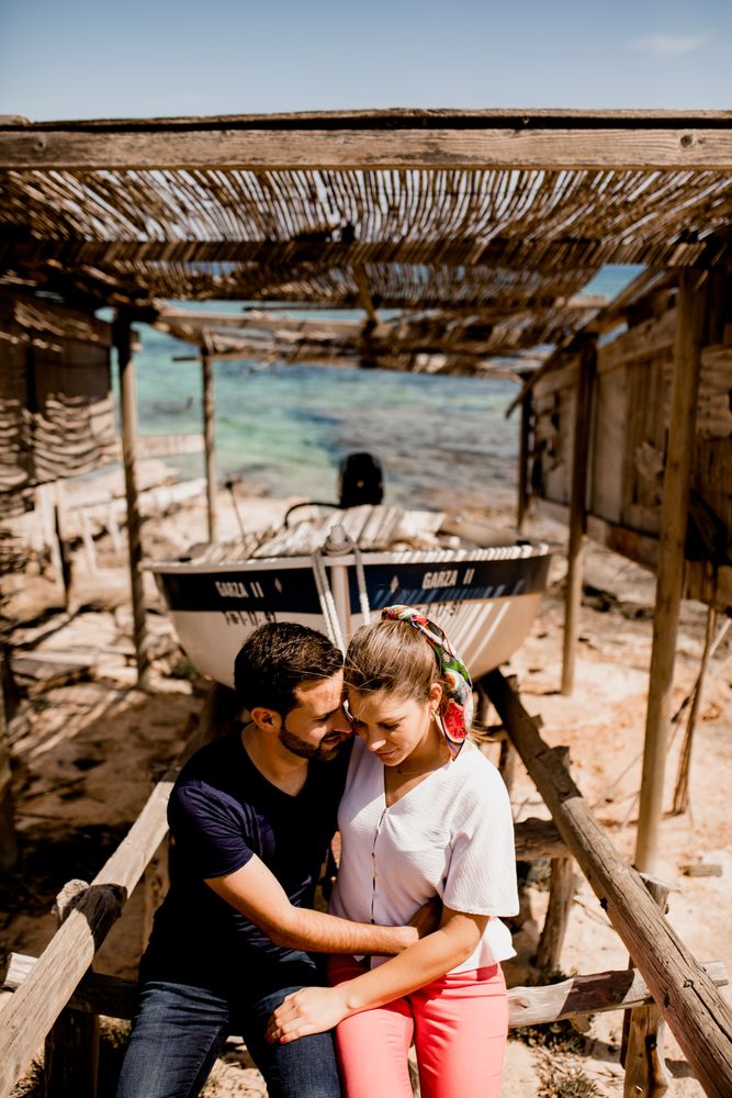 Loving couple hugging near boat dragged ashore