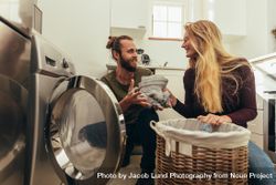 Couple using a front loading washing machine to wash laundry 43RPZ5
