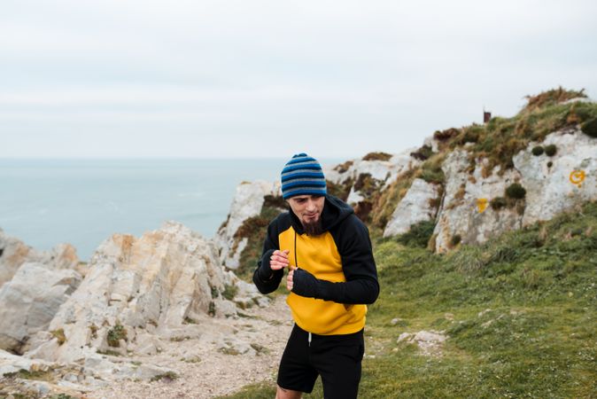 Kickboxer training on cliff near sea