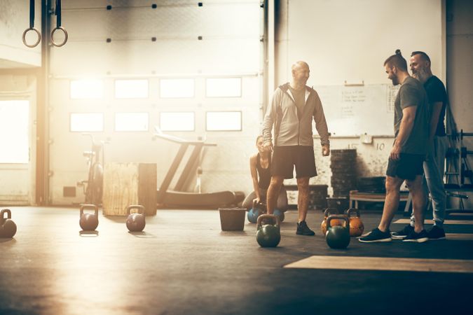 Group of men having a casual conversation in a weightlifting gym