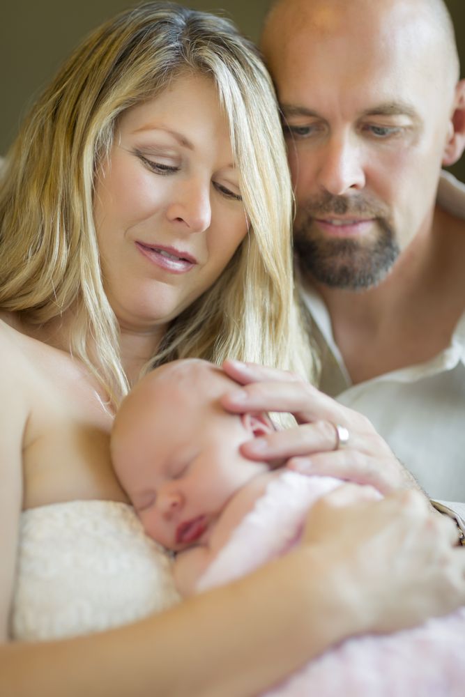 Loving Couple Holding Their Newborn Baby Girl