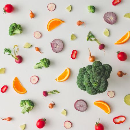 Colorful vegetable pattern made of onion, broccoli, orange and yellow flowers