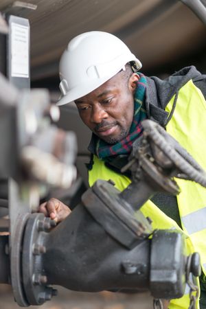 Man wearing safety equipment checking and inspecting gear train