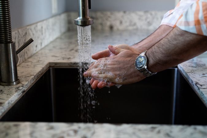 Man’s hands with watch washing up to prevent illness