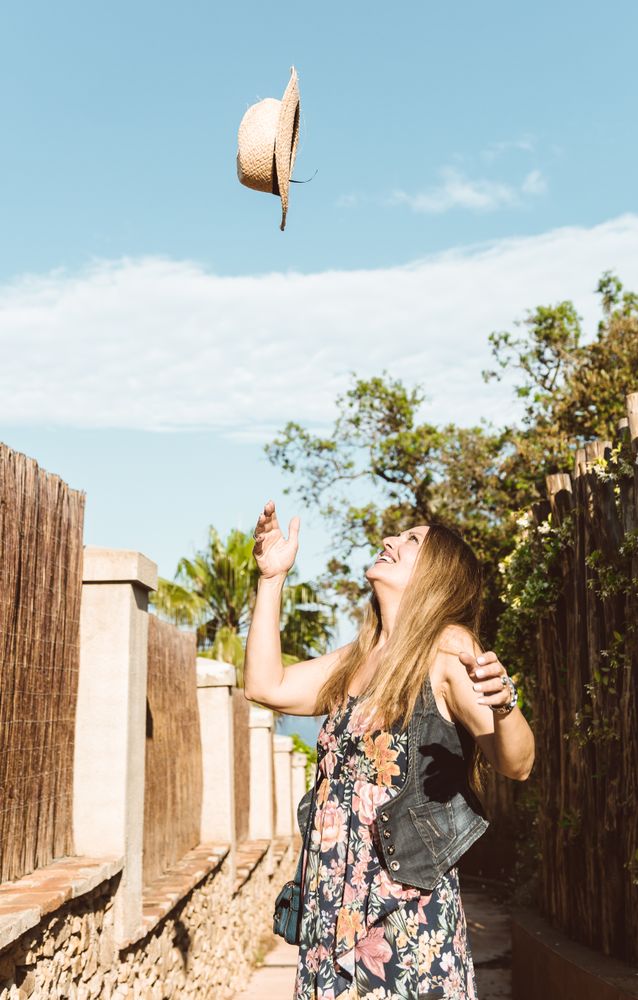 Happy woman throwing hat up
