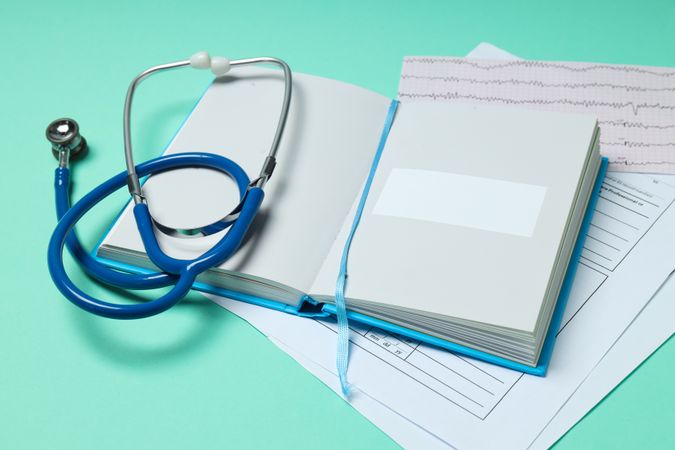 Medical literature - book and medical accessories on mint background
