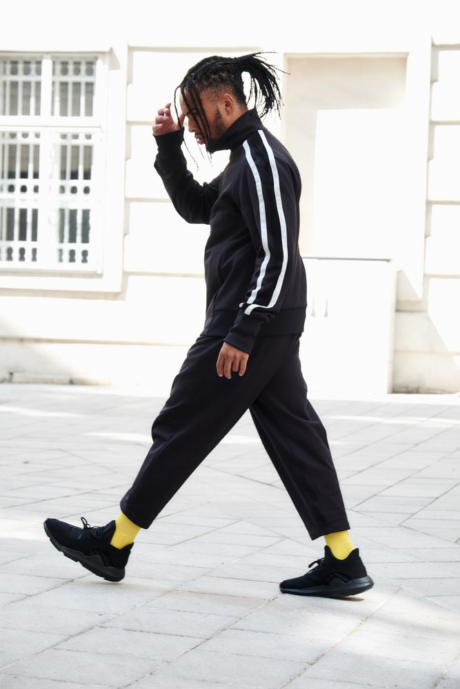 Black braided male walking down street