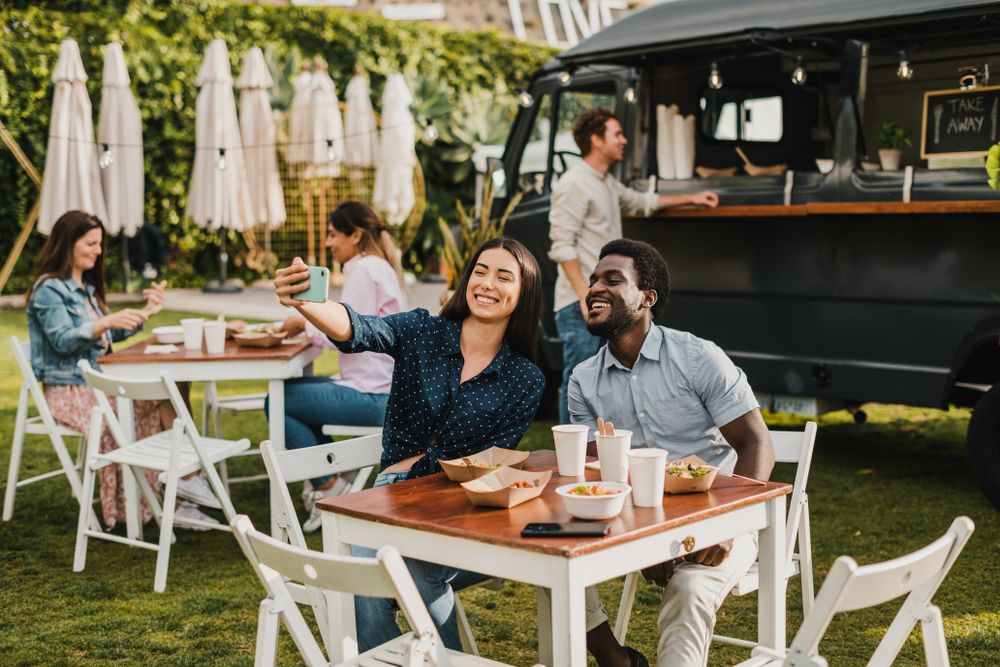 Diverse friends taking selfie outside food truck