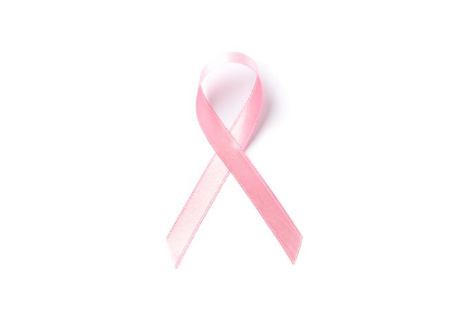 Pink awareness ribbon isolated on blank background, top view