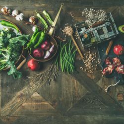 Assortment of seasonal winter vegetables, pomegranates, peppers, broccoli on wooden table