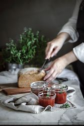 Fresh bread on napkin near tomatoes jam