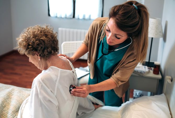 Caregiver auscultating woman