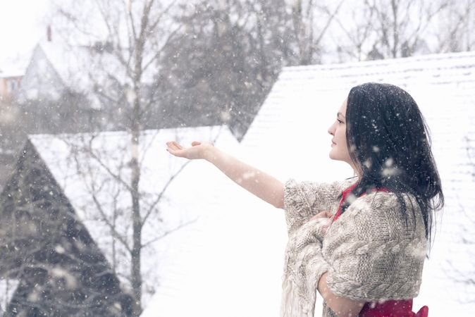Beautiful woman catching snowflakes