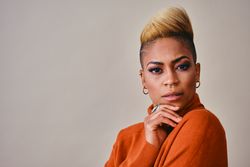 Studio shot of curious Black woman with short blonde hair