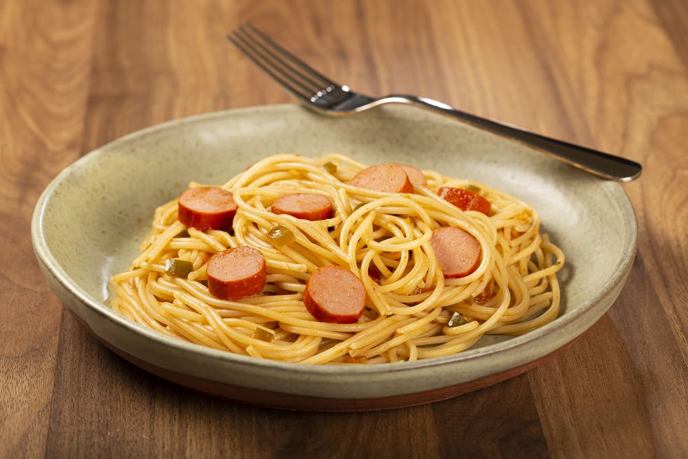 spaghetti pasta with sliced sausages and tomato sauce.