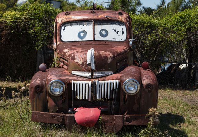 Rusty abandoned car painted as Pixar “Cars” character