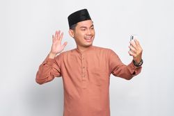 Muslim man in kufi hat talking on video call