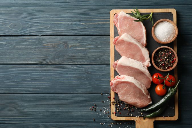 Composition with raw meat for steak and ingredients on wooden background