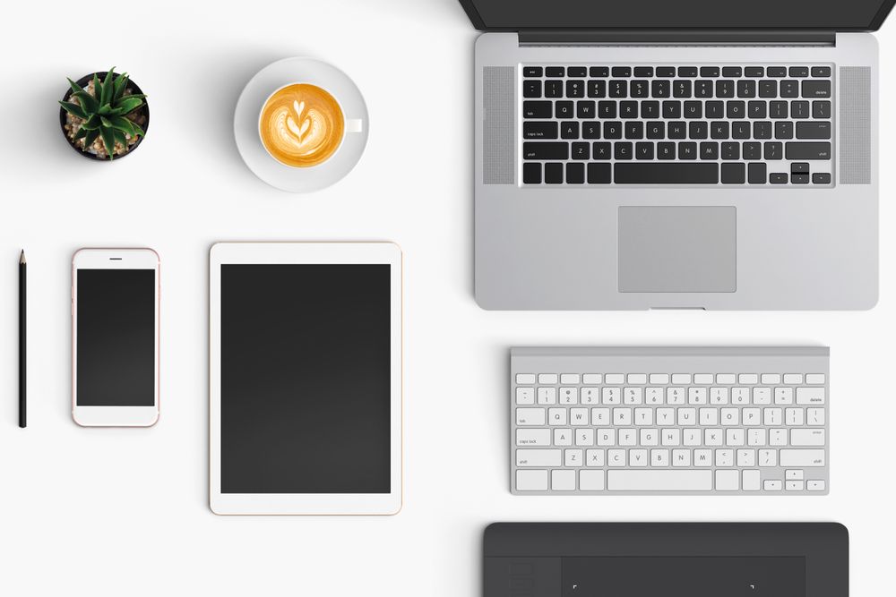 Modern workspace with coffee cup, smartphone, paper, notebook, tablet and laptop