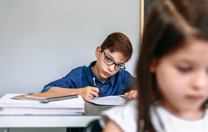 Teen writing in notebook at school