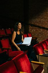 Female director observing the stage from the theater