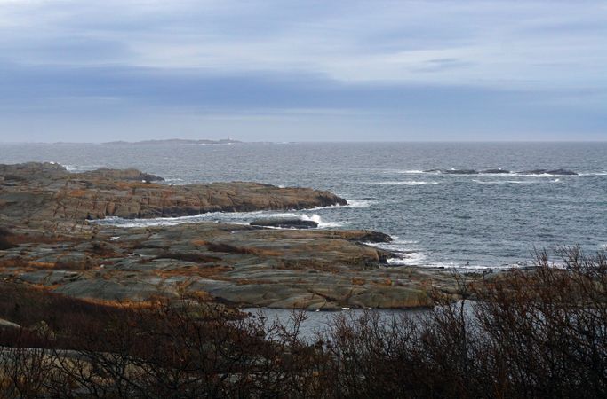 Rocky seashore and dark wavy sea in dusk